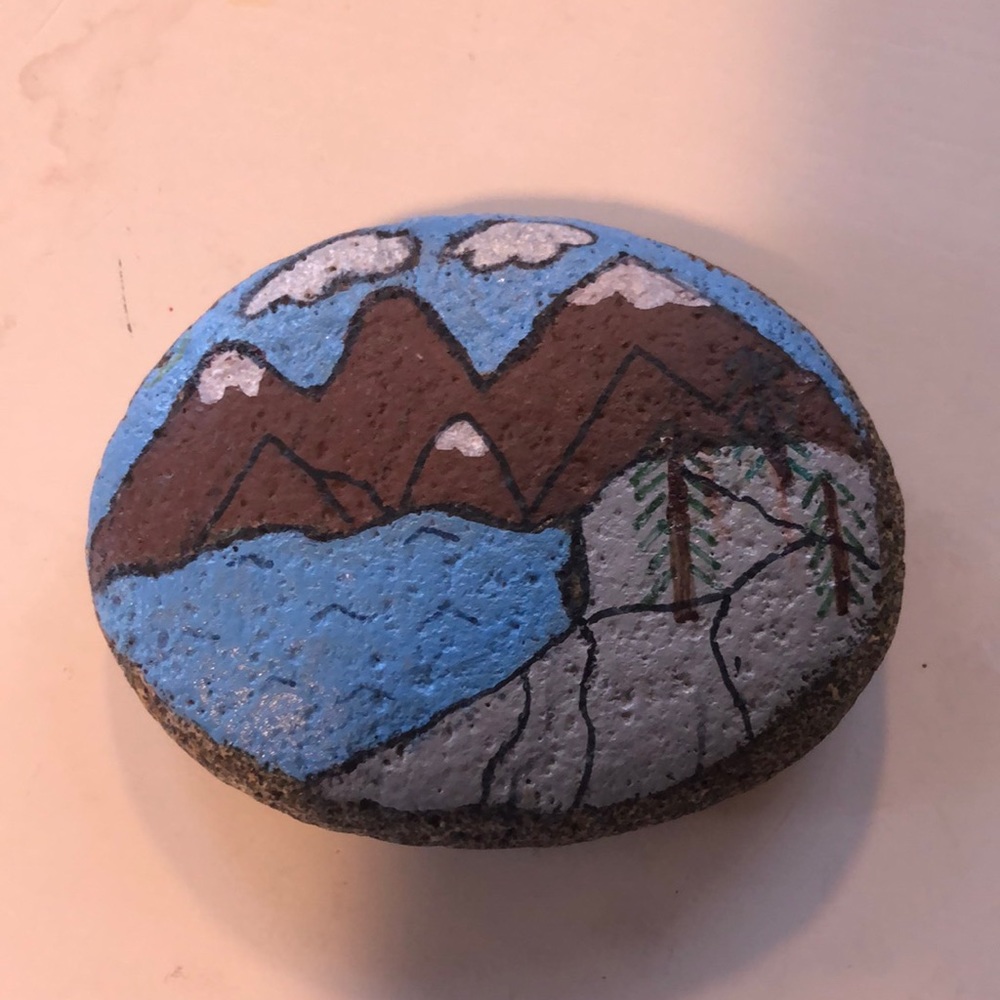 Handpainted garden art with mountain scene on it